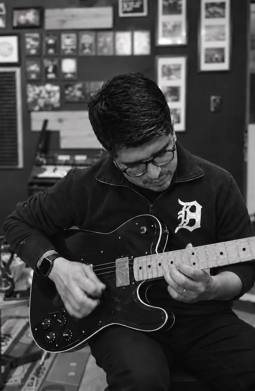 Martín Beas tocando una guitarra eléctrica negra en un estudio, en blanco y negro.